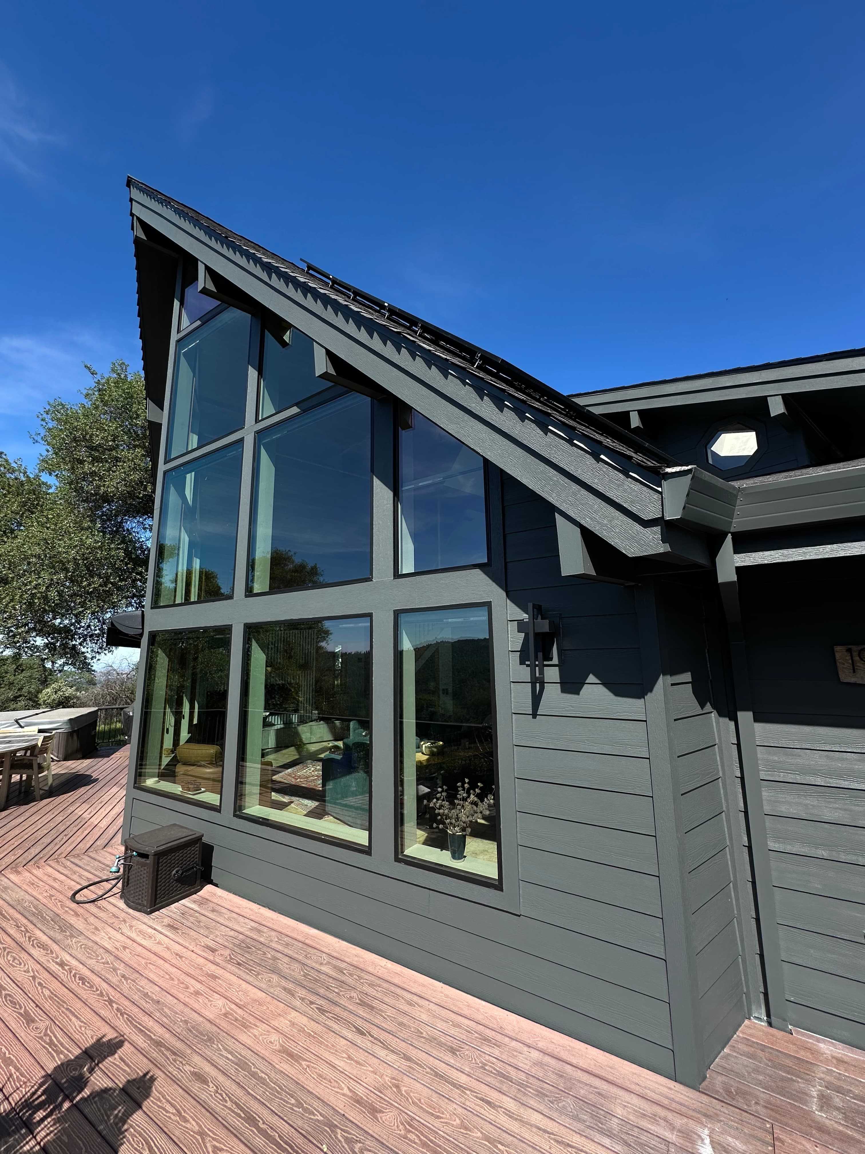 Floor to ceiling windows and board and batten siding in Sacramento foothills by NorCal Exteriors